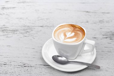 Latte üzerinde beyaz ahşap masa kahve bir fincan