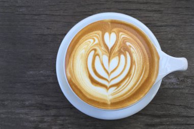 Latte sanat ahşap arka plan üzerinde kahve
