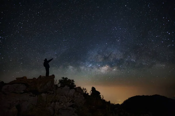 A Man is standing next to the milky way galaxy pointing on a bright star on Doi Luang Chiang Dao mountain — Stock Photo, Image