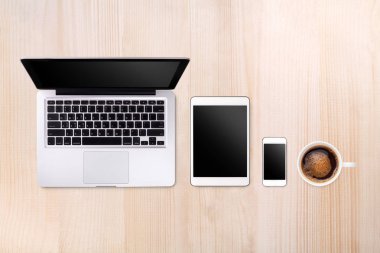 Laptop tablet smartphone ve ahşap masa arka plan üzerinde kahve