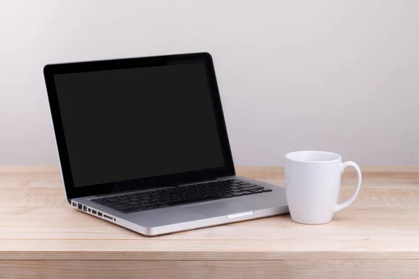 Vista frontal de la computadora portátil y el café está en la mesa de trabajo concreto — Foto de Stock