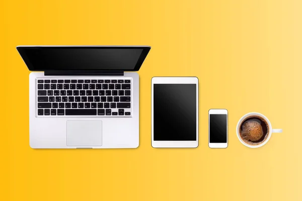 Laptop tablet smartphone e café no fundo amarelo com t — Fotografia de Stock