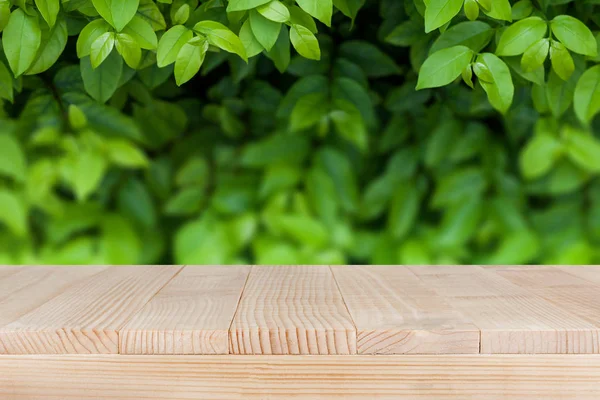 Braun Holz Tischplatte auf Bokeh abstrakte grüne Natur Hintergrund - — Stockfoto