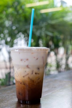 Buzlu kahve latte doğa bokeh arka plan üzerinde paket servisi olan restoran Kupası