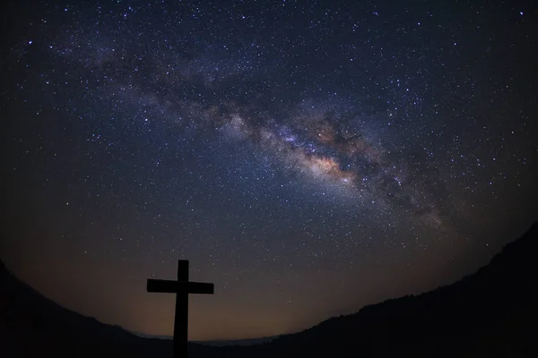 Silhouette of cross over milky way background,Long exposure phot