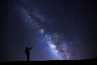 Parlak bir yıldız Samanyolu galax ile işaret eden duran bir adam