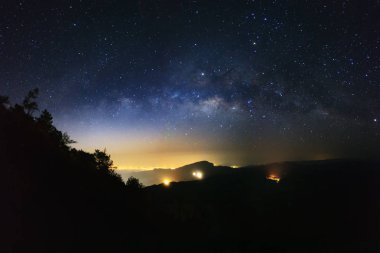 Samanyolu ve ağaç ile şehir silüeti ışık Doi üzerinde ben