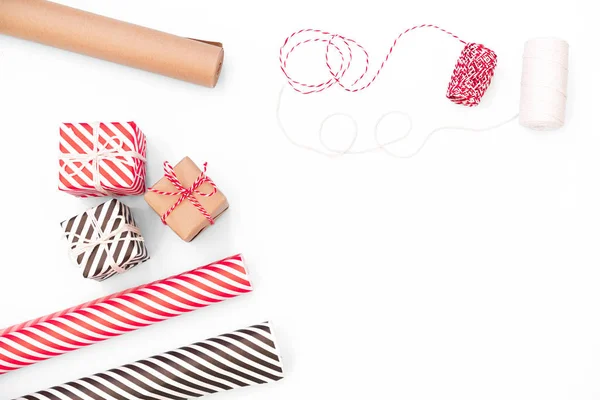 Flache Liege mit Weihnachtsgeschenk, Geschenkpapier, Band auf weißer Tischplatte. — Stockfoto