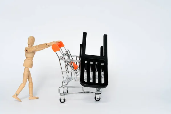 Ξύλινο άνθρωπος μεταφέρουν σούπερ μάρκετ ψώνια whith μαύρη καρέκλα σε αυτό που απομονώνονται σε λευκό — Φωτογραφία Αρχείου