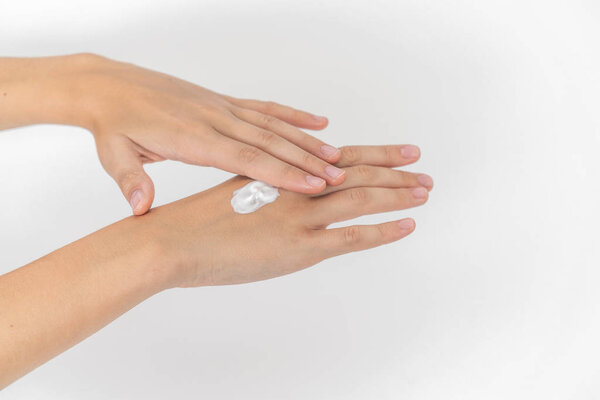 Hand skin care. Closeup on womans hands applying moisturizing hand cream on. 
