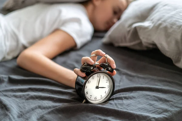 Mujer con insomnio acostada en la cama con la cabeza bajo la almohada tratando de dormir . —  Fotos de Stock