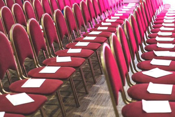 Řady červených židlí v konferenčním sále, prázdné zasedací nebo společenské místnosti. Prázdná místa pro hosty — Stock fotografie