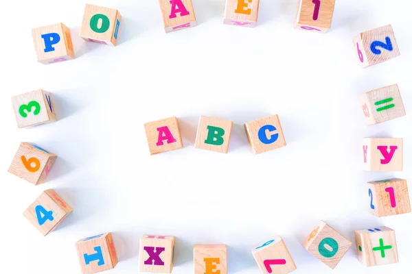 Kids toys wooden cubs with letters and numbers on white background. — Stock Photo, Image