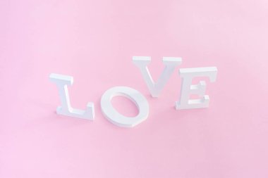 Pembe arka planda beyaz cilt harflerinden kelime aşkı