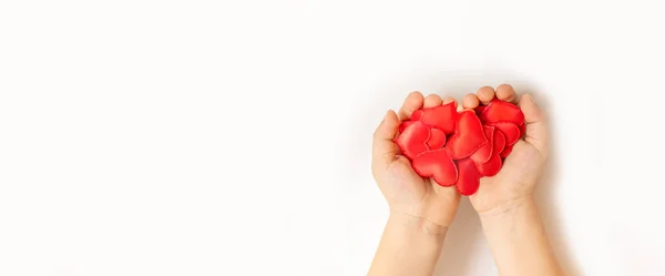 Detailní záběr dětských rukou drží červené srdce bílé pozadí — Stock fotografie