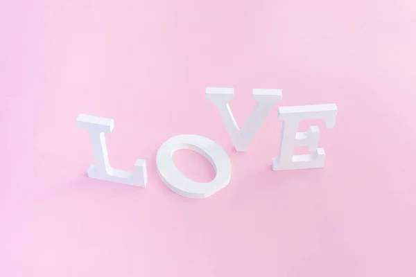 Palabra de amor de letras de volumen blanco sobre fondo rosa —  Fotos de Stock