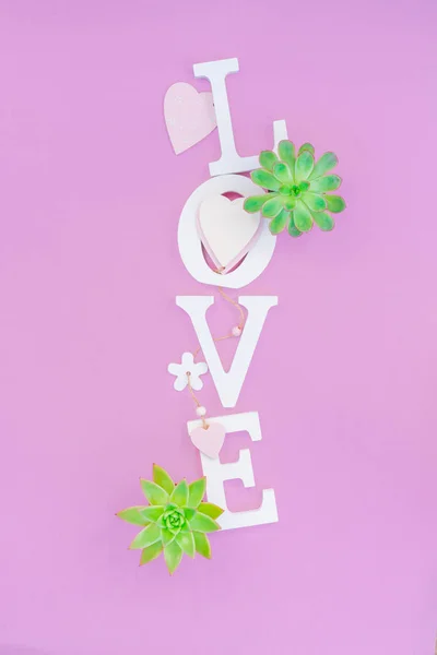 Slovo láska z bílých svazků písmen na růžovém pozadí — Stock fotografie
