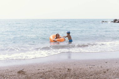 Mutlu aile - kız kardeş ve erkek kardeş Ben denizde eğlenerek yüzerim. 