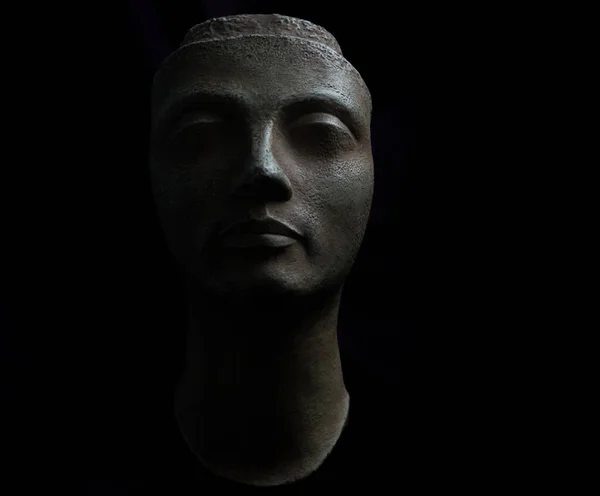 Ancient Greek bust that depicts the face of a female figure. Black background studio photography.