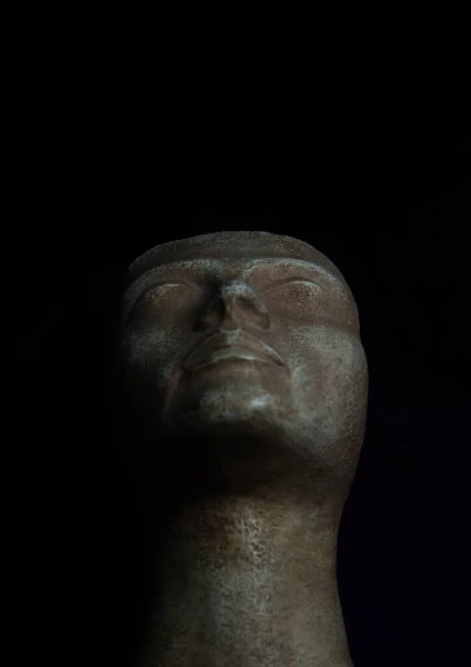 Ancient Greek bust that depicts the face of a female figure. Black background studio photography.