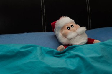 Noel Baba, bebek, evin yatağında uzanmış, büyük Noel gezisinden dinleniyor..