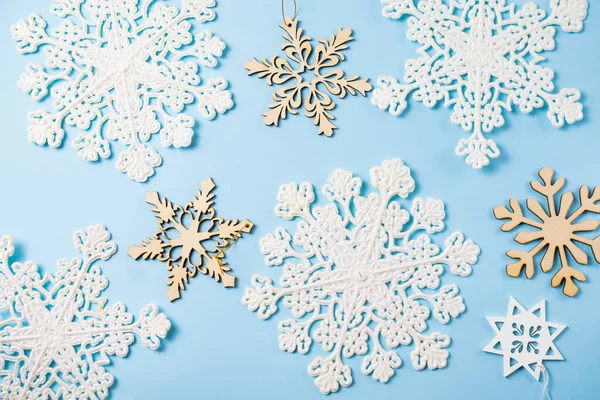 Weihnachten blauer Hintergrund mit funkelnden weißen und hölzernen Schneeflocken. — Stockfoto