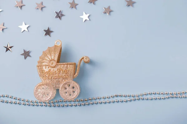 Funkelnder goldener und silberner Kinderwagen mit Sternen auf blauem Hintergrund und Weihnachtsdekor. Grußkarte. Overhead-Flatlay mit Kopierraum für Ihren Text — Stockfoto