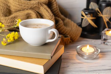 Hygge yaşam tarzı kahve, mumlar, kitaplar ve ekose kumaşlı.