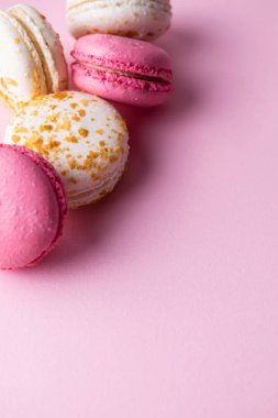 French pink and white macarons on pink pastel background. Top view with copy space for your text.