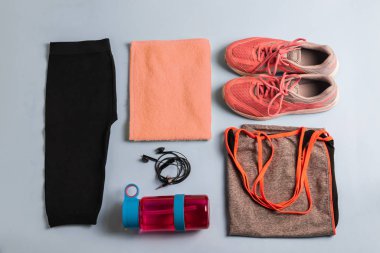 Kilo vermek isteyen bir grup sporcu ya da kadın. Spor tişörtü ve pantolonlar, kulaklıklar, pembe parlak su şişeleri, spor ayakkabıları ve beyaz ahşap arka planda bir havlu. Metnin için kopyalama alanı