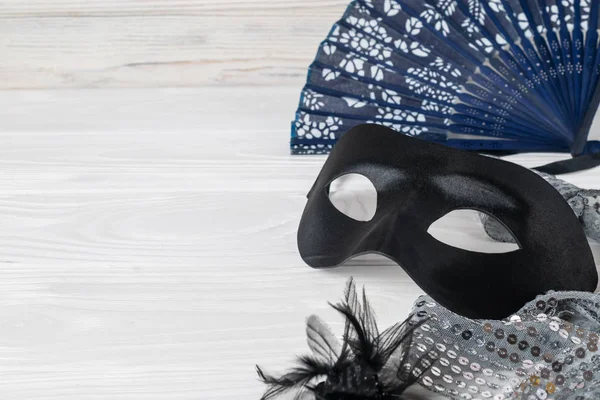 Festliche Karnevalsaccessoires, schwarze Maske, eleganter Vintage-Fächer und Schmuck auf weißem Hintergrund. flache Liegefläche mit Kopierraum für Ihren Text — Stockfoto
