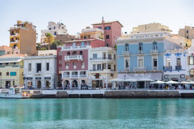Agios Nikolaos, Girit, Yunanistan. 2019. Mirabello Körfezi 'nin kuzeybatısındaki Voulismeni Gölü' nün yanı sıra balıkçı tekneleri ve restoranları olan liman ve şehir manzarası..