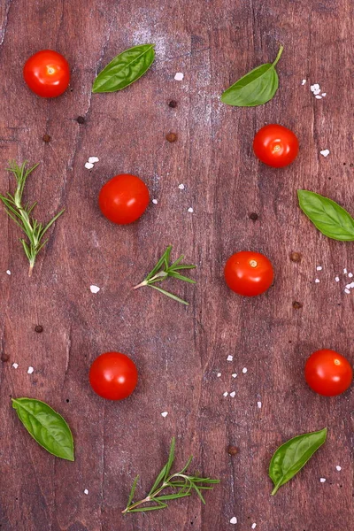 Tomates frescos, albahaca y romero sobre una mesa de madera. Fondo estacional con verduras y hierbas . —  Fotos de Stock