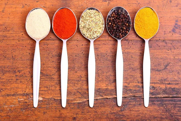 Färgstarka kryddor på skedar. Mat bakgrund. — Stockfoto