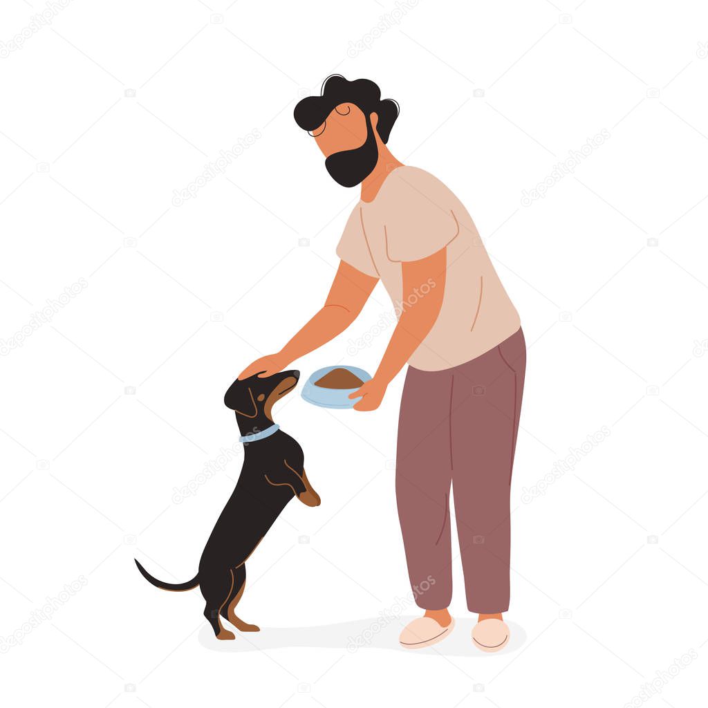 Young man feeding dog and petting on his head