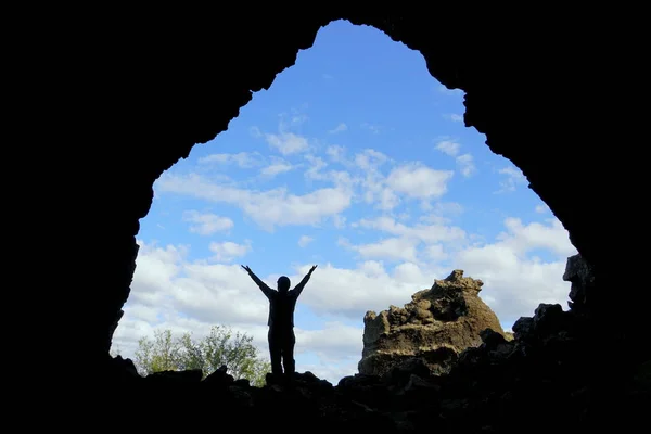 A silhouette of a man posed in front of the old church rock structure at Dimmuborgir Lava Formations, near Lake Myvatn, Iceland in the summer