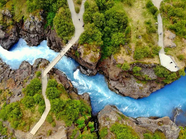 A vista aérea do rio azul leitoso e uma ponte perto de Barnafoss Falls, Islândia . — Fotografia de Stock