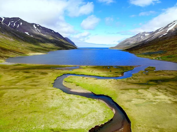 La vista aerea di un torrente blu che scorre nel lago vicino a Hedinsfjordur, Islanda — Foto Stock