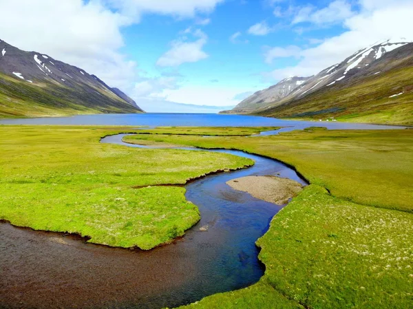 La vue aérienne d'un ruisseau bleu coulant dans le lac près de Hedinsfjordur, Islande — Photo