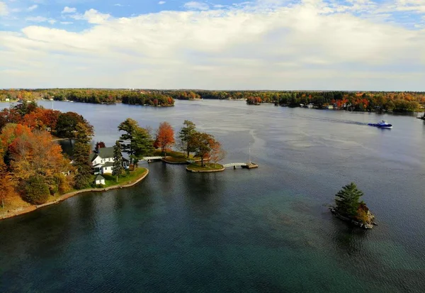 The aerial view of the waterfront residential area surrounded by striking fall foliage by St Lawrence River of Wellesley Island, New York, U.S.A — Stock Photo, Image