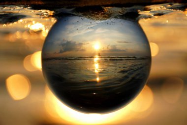 Beautiful sunset captured through a glass lens ball at Cape Henlopen State Park, Lewes, Delaware, U.S.A clipart