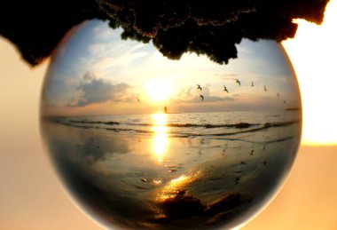 Beautiful sunset captured through a glass lens ball at Cape Henlopen State Park, Lewes, Delaware, U.S.A clipart