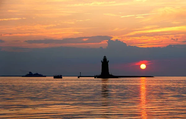 Deniz fenerinin silueti ve günbatımında Cape Henlopen Eyalet Parkı 'nda tekneler, Lewes, Delaware, ABD