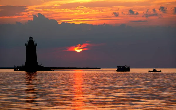 Deniz fenerinin silueti ve günbatımında Cape Henlopen Eyalet Parkı 'nda tekneler, Lewes, Delaware, ABD