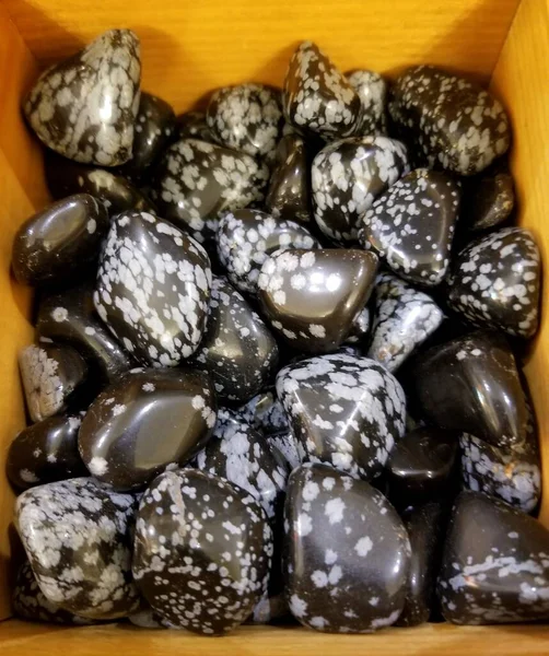 Una pila de hermosas piedras de obsidiana de copo de nieve blancas y negras — Foto de Stock