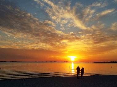 Cape Coral, Florida yakınlarında gün batımını izleyen bir çiftin silueti.