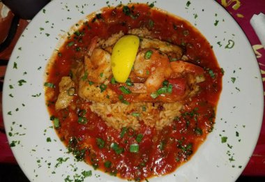 Beyaz tabakta pilav ve baharatlı yayın balığı.