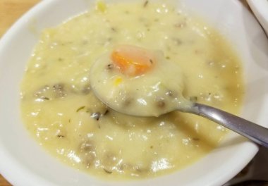 Gümüş kaşıkta tavuk ve yabani pirinç çorbası.