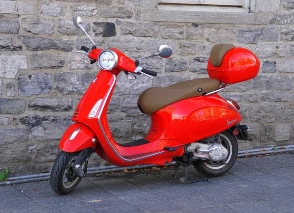 Montreal, Kanada - 27 Ekim 2019 - Sokağa park etmiş parlak kırmızı bir Vespa scooter