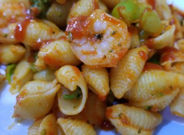 Kırmızı soslu makarna kabuğu brokoli ve karides.